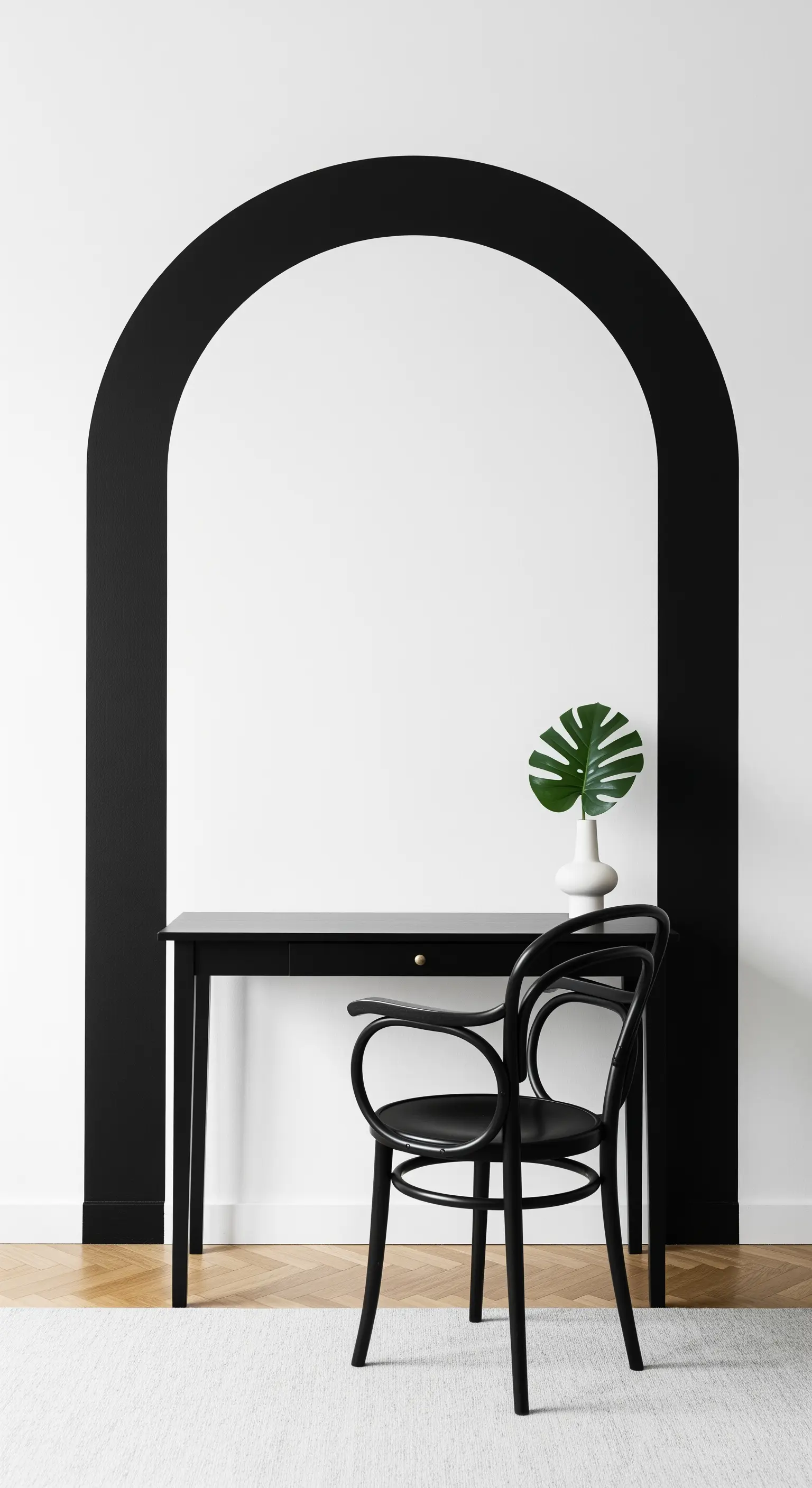 Scrivania nera posizionata all'interno di un grande arco nero dipinto su una parete bianca.