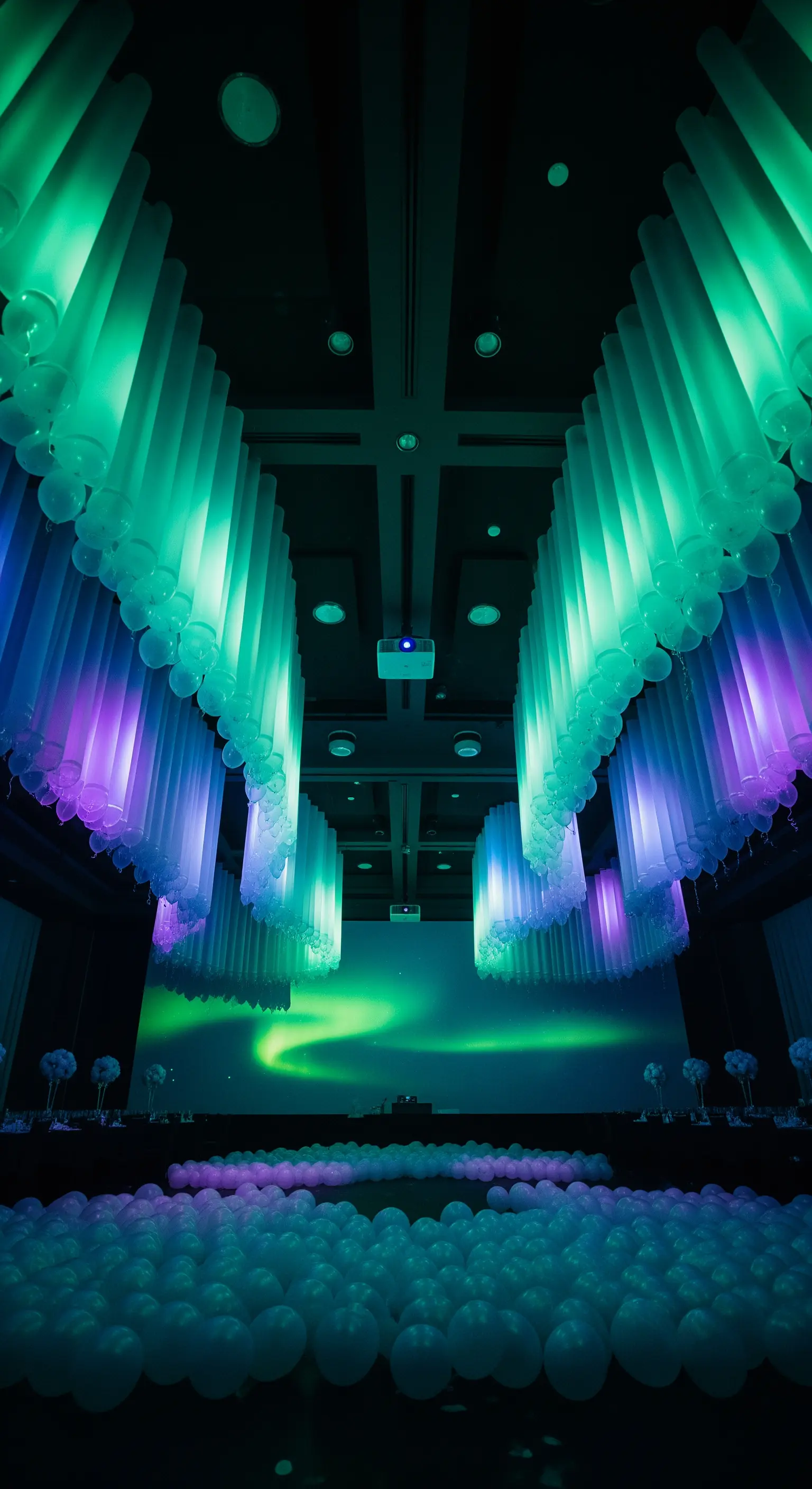Installazione che simula l'aurora boreale con palloncini sospesi e luci verdi e viola.