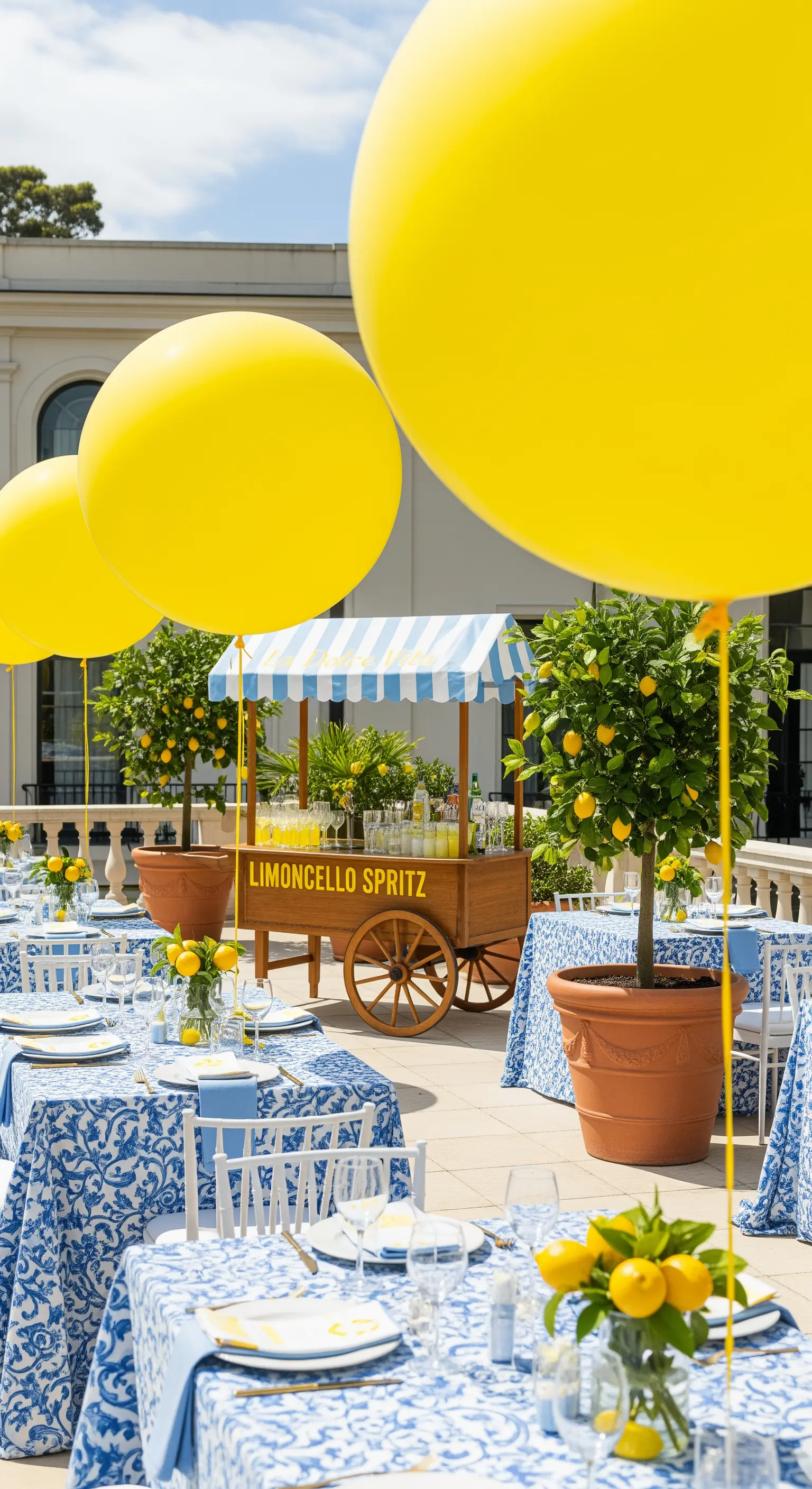Festa a tema limoncello con tovaglie a maiolica, alberi di limoni e palloncini gialli.