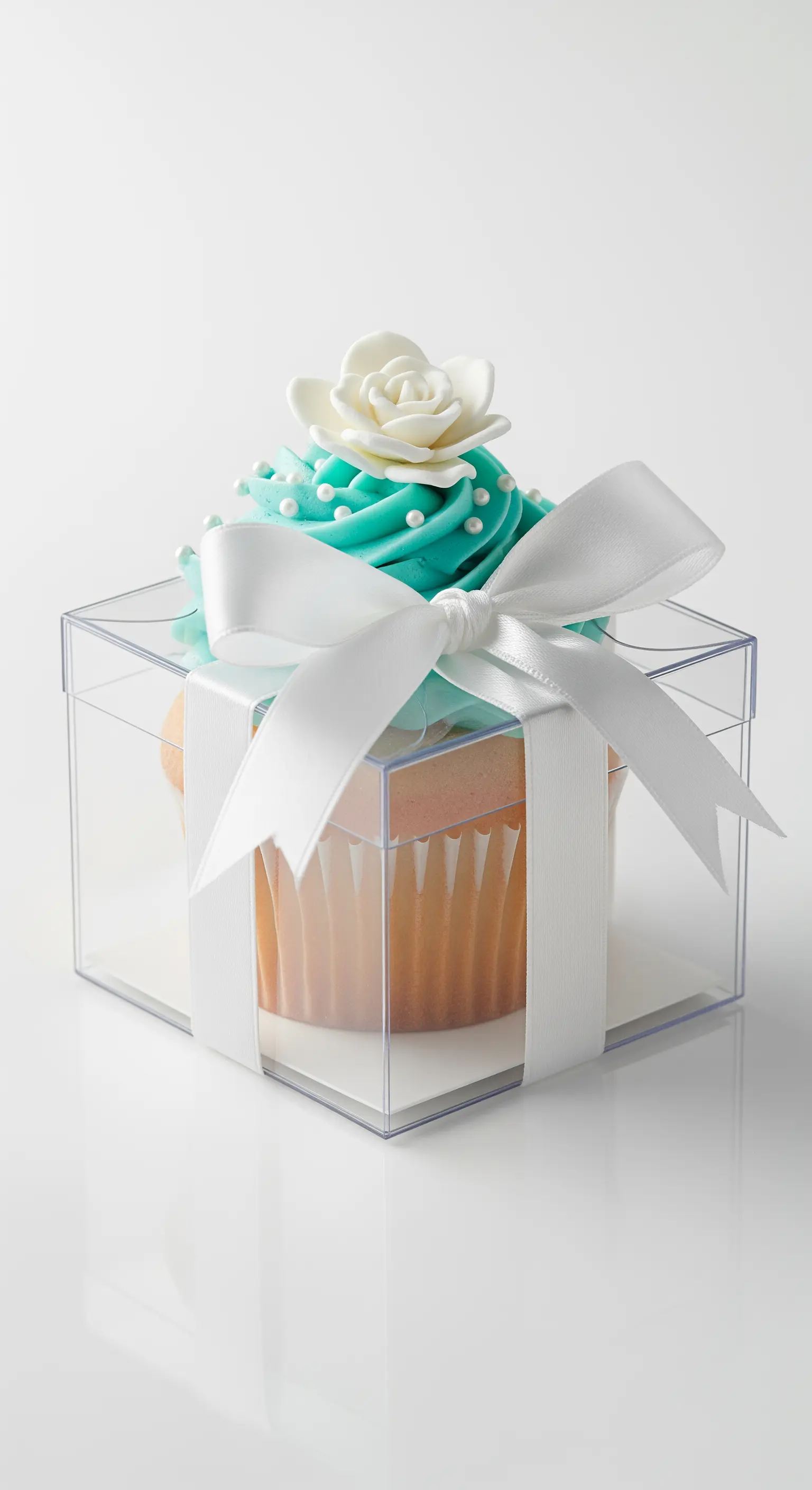 Cupcake color tiffany con fiocco di raso bianco e decorazioni di perle.