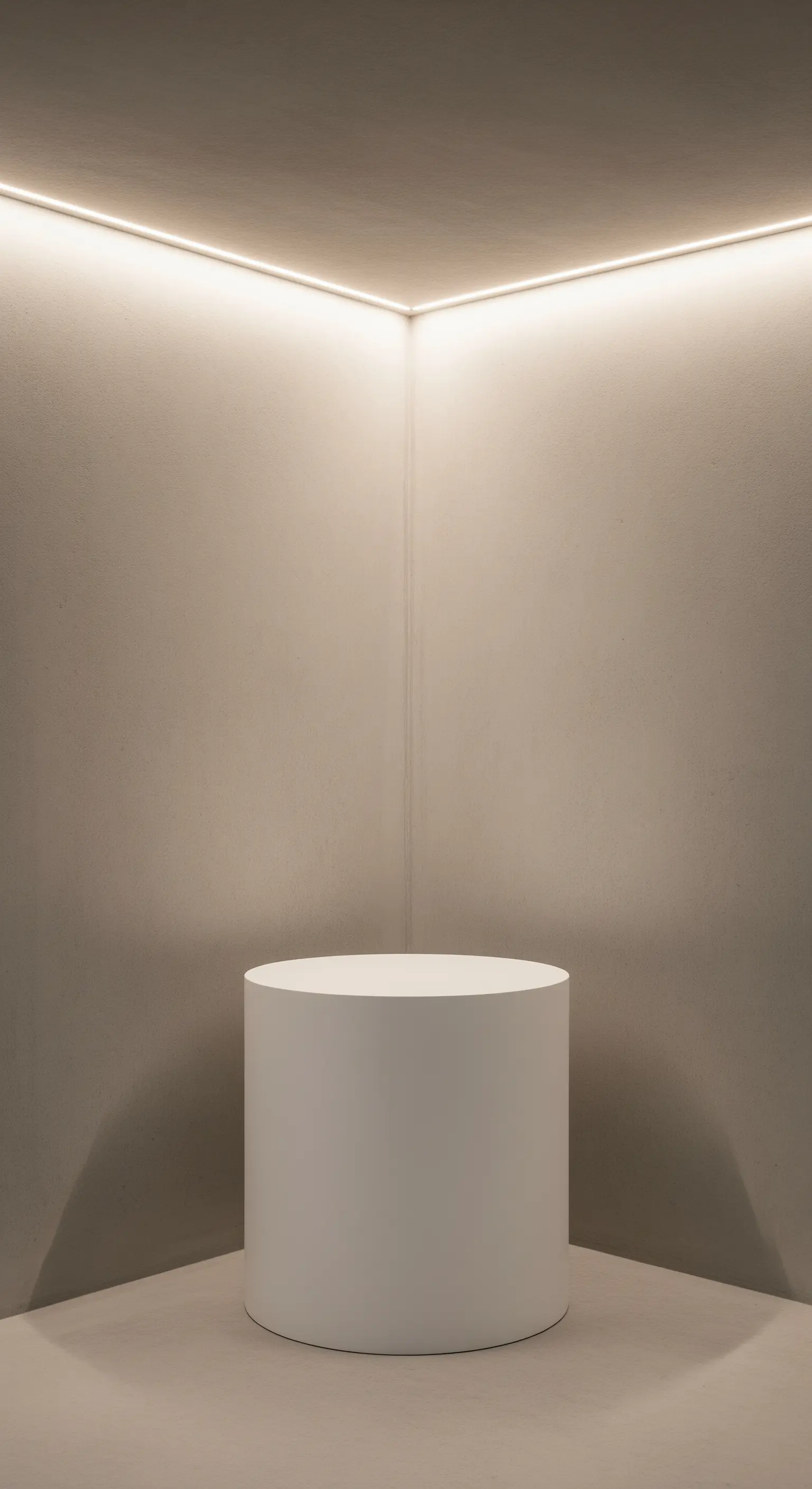 Angolo vuoto con illuminazione a LED nel soffitto e piedistallo bianco.