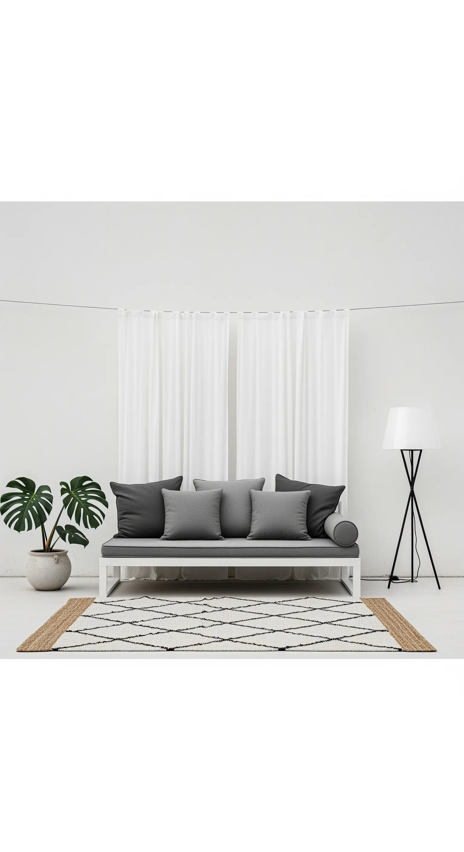 Allestimento minimalista con divano grigio, tappeto a rombi e pianta di monstera.