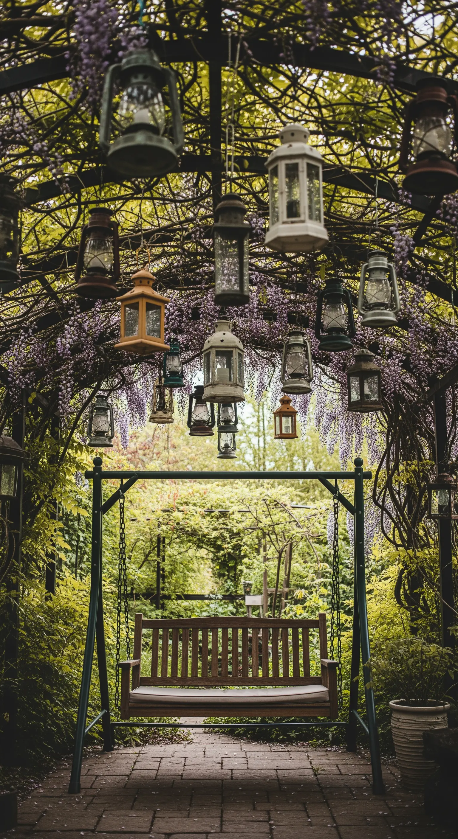 Un'altalena sotto un arco fiorito, decorato con una collezione di lanterne vintage diverse.