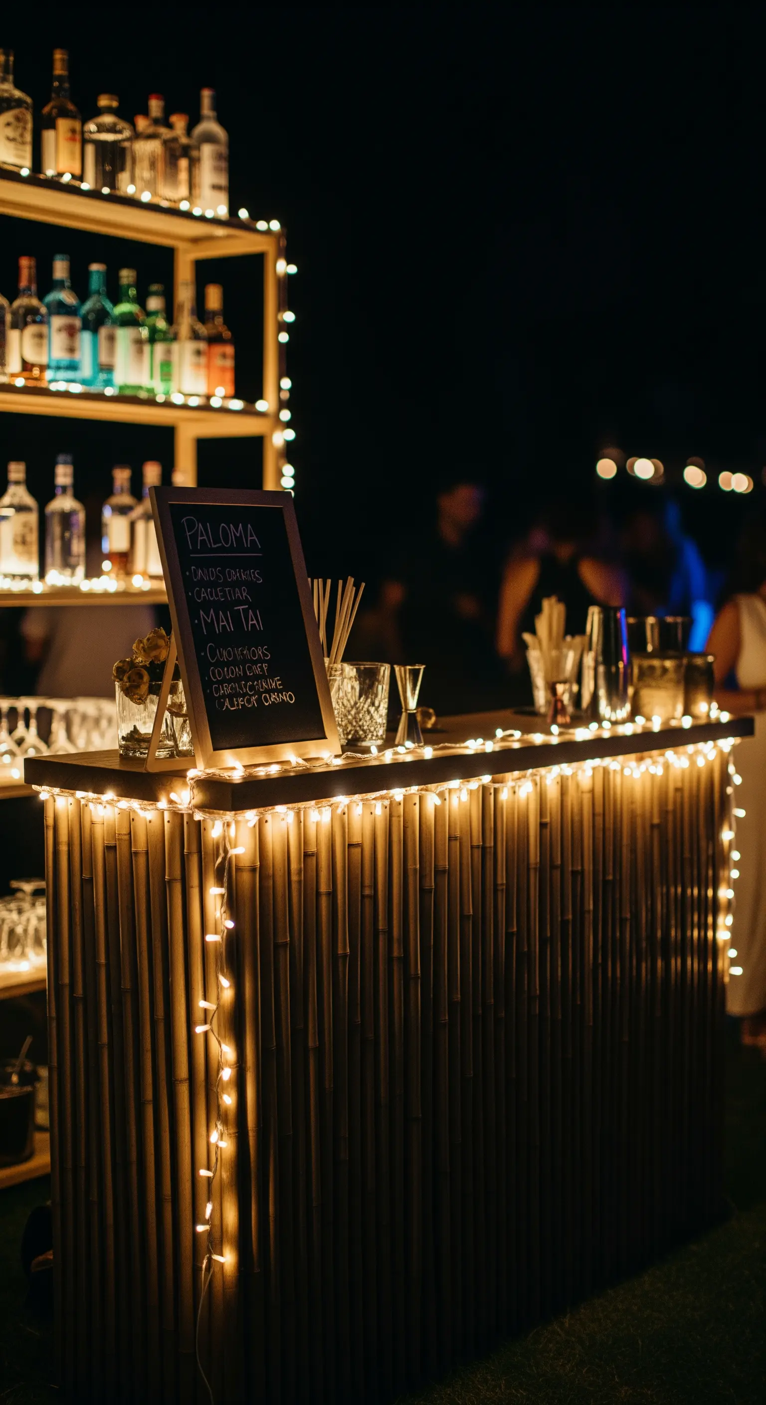 Bar in bambù fai-da-te illuminato di notte da una stringa di luci calde.