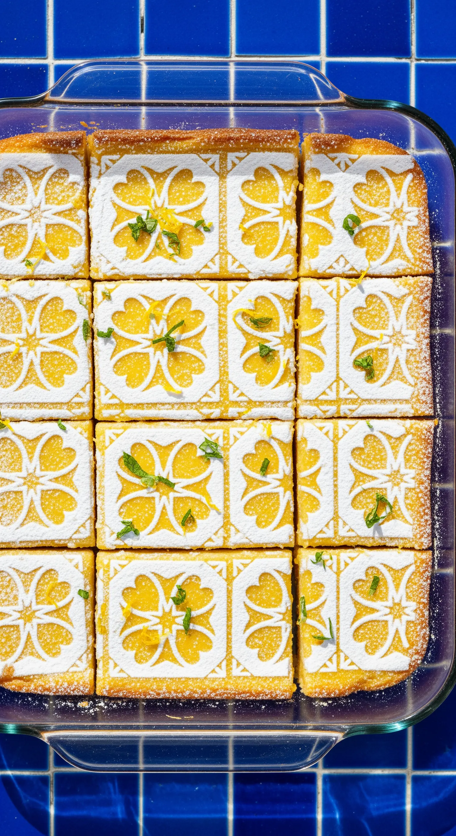 Torta al limone in teglia tagliata a quadrotti, decorati con un motivo a piastrella.