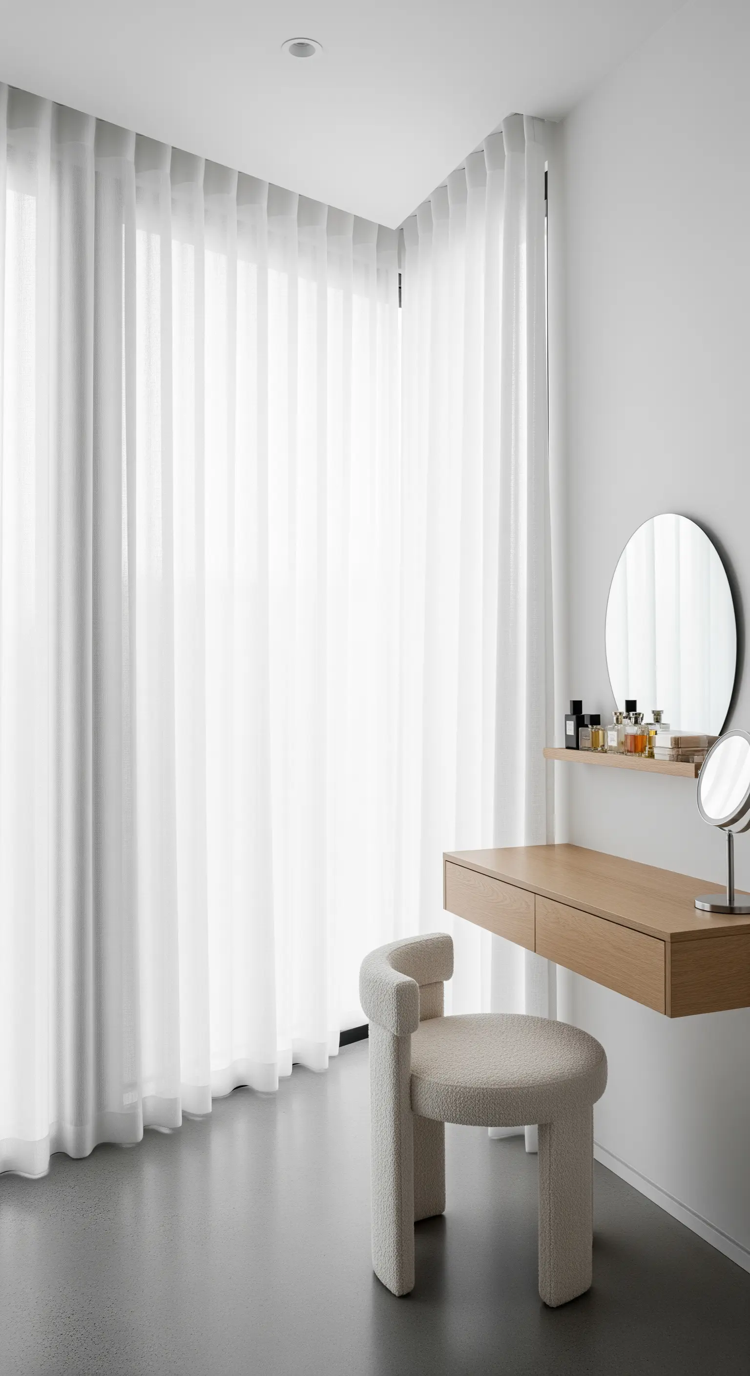 Postazione trucco minimalista con consolle sospesa e tende bianche a tutta parete.