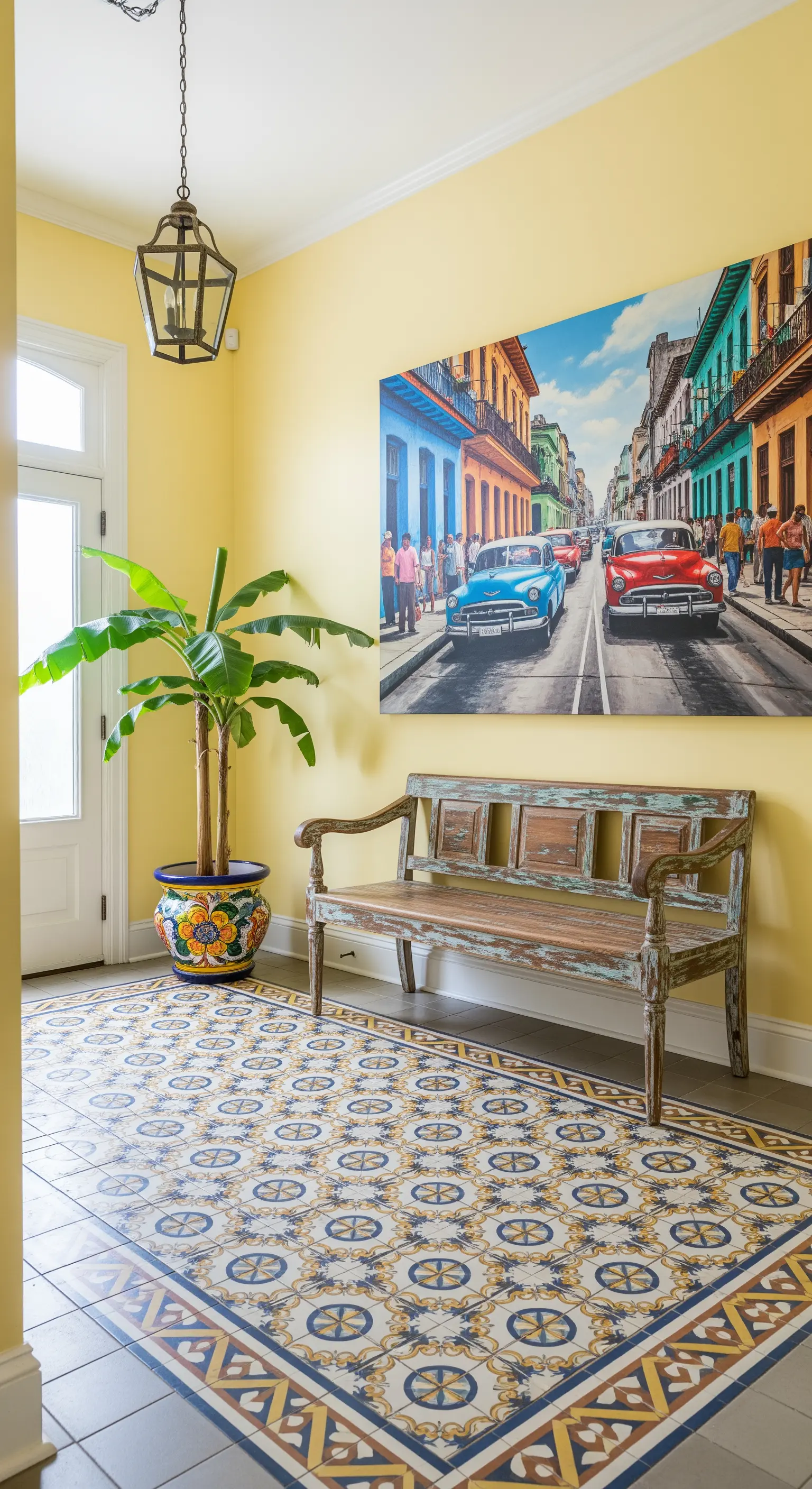 Ingresso con piastrelle decorate a terra, pareti gialle e un quadro di una strada cubana.