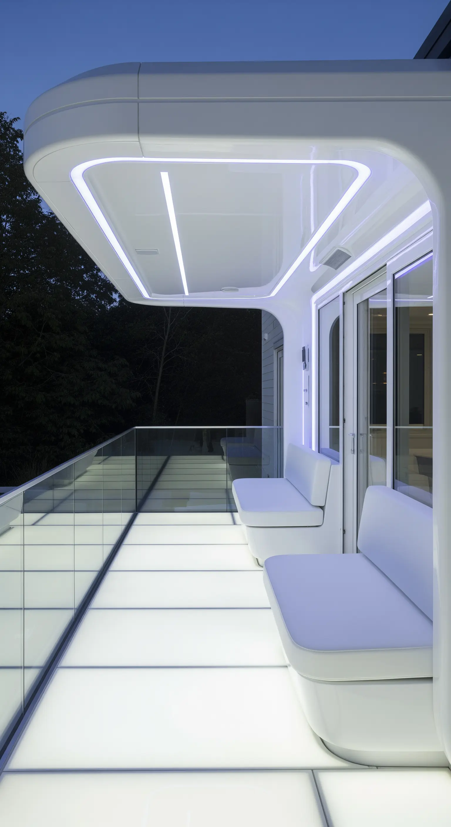Veranda futuristica bianca con forme curve, panche integrate e pavimento e soffitto retroilluminati