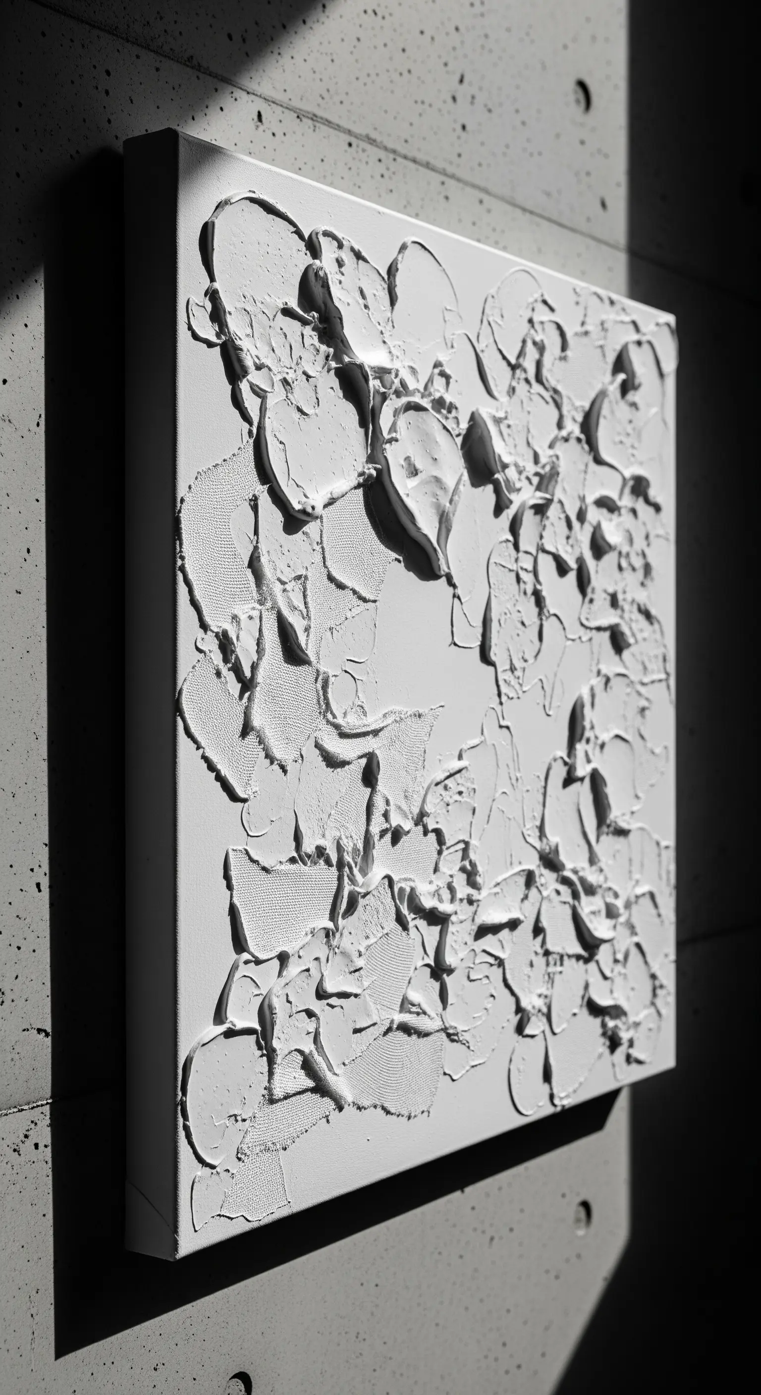 Quadro monocromatico bianco con texture a rilievo, creato con applicazioni di gesso o stucco.