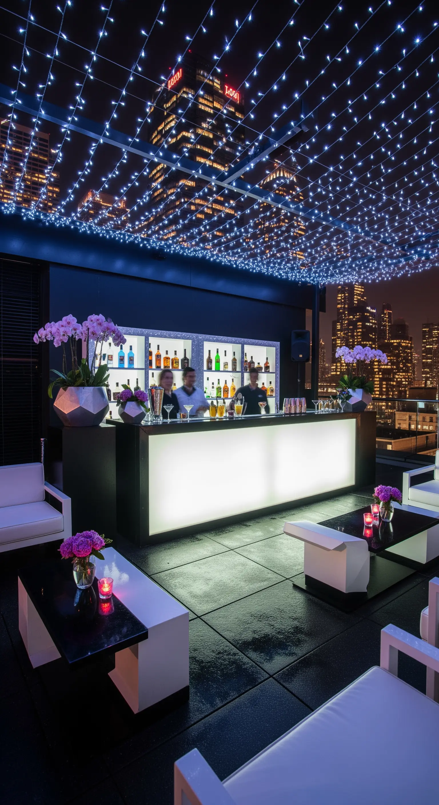 Terrazza urbana con un soffitto di lucine a led, bar luminoso e skyline notturno.