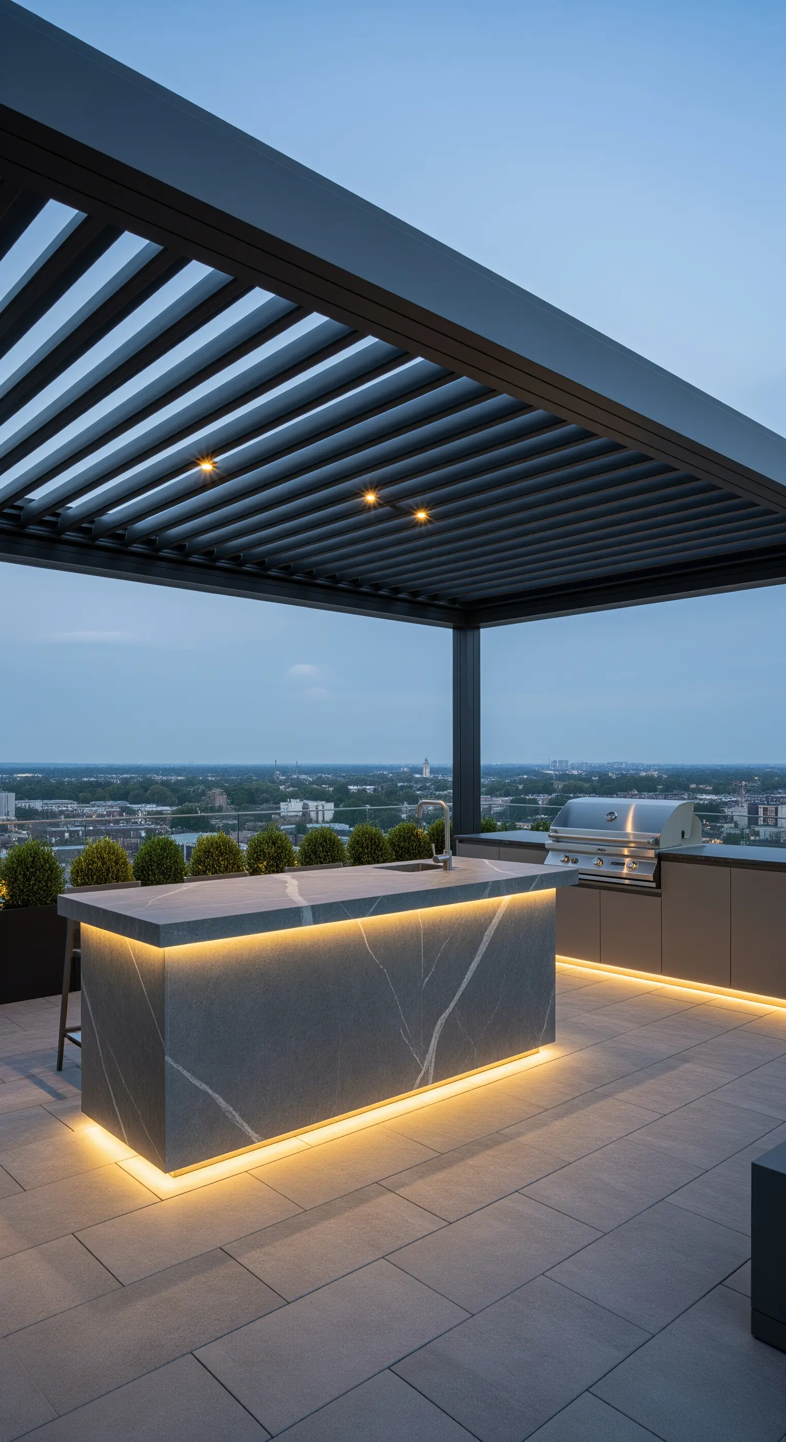 Moderna cucina da esterno su un rooftop, con isola in gres effetto marmo e luci a LED.