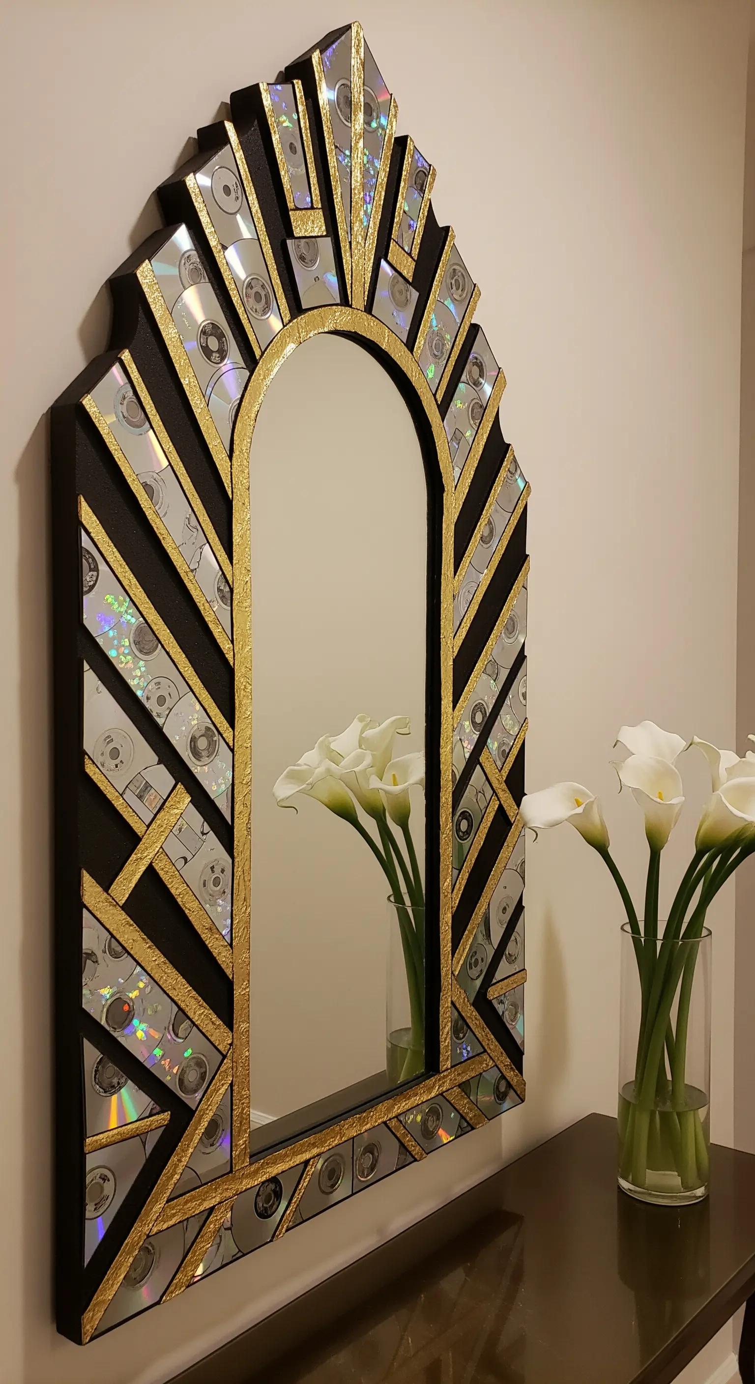 Specchio in stile Art Déco con cornice nera, dettagli dorati e inserti di CD riciclati.