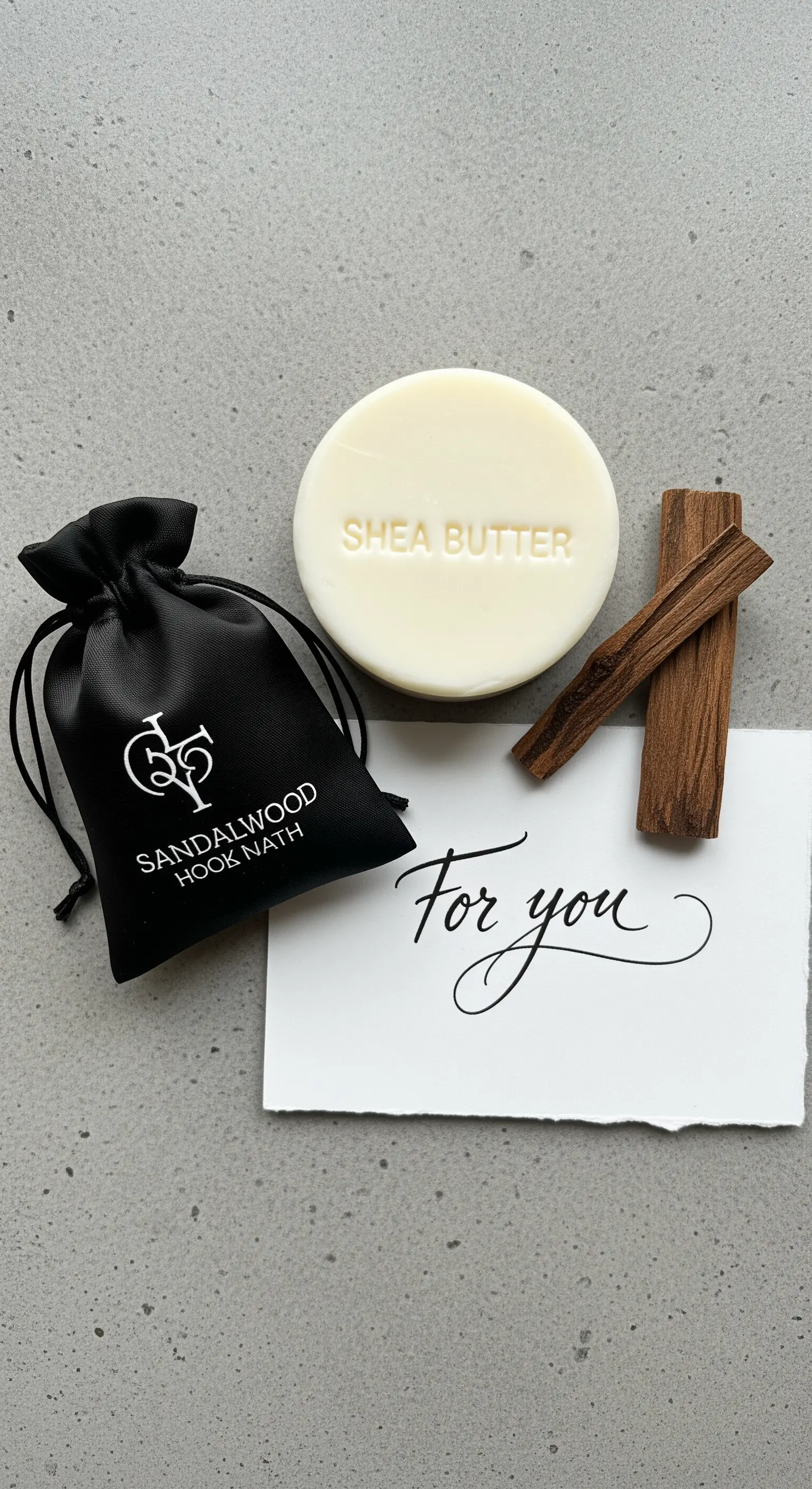 Sapone al burro di karité, sacchetto nero di raso, bastoncini di sandalo e un biglietto scritto a mano.