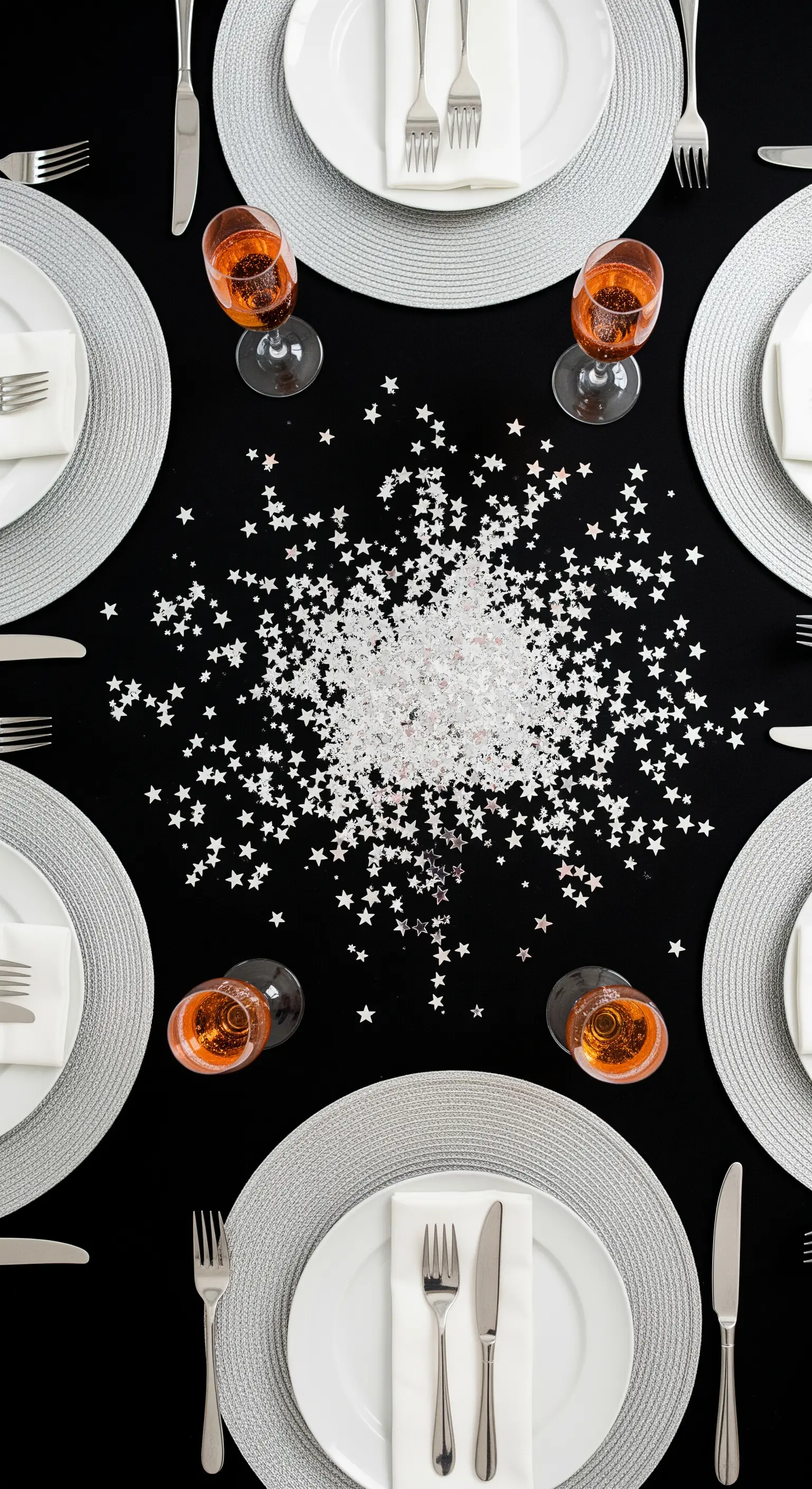 Tavola rotonda con coriandoli a forma di stella sparsi al centro come decorazione.