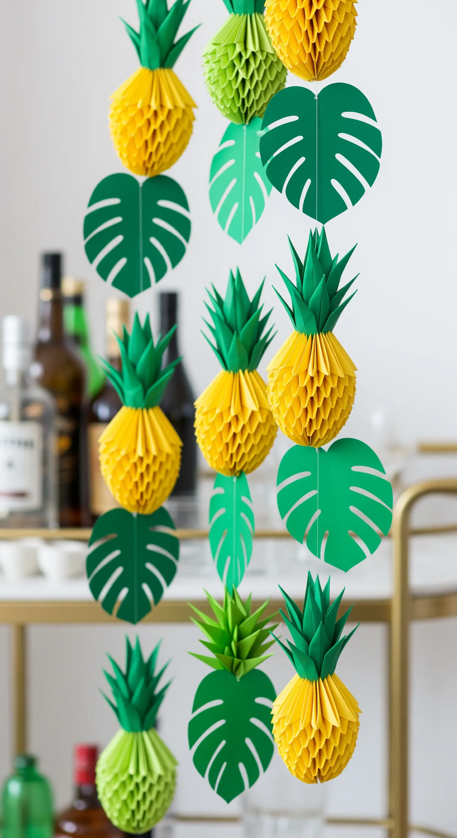 Ghirlanda verticale con ananas tridimensionali e foglie di monstera di carta.