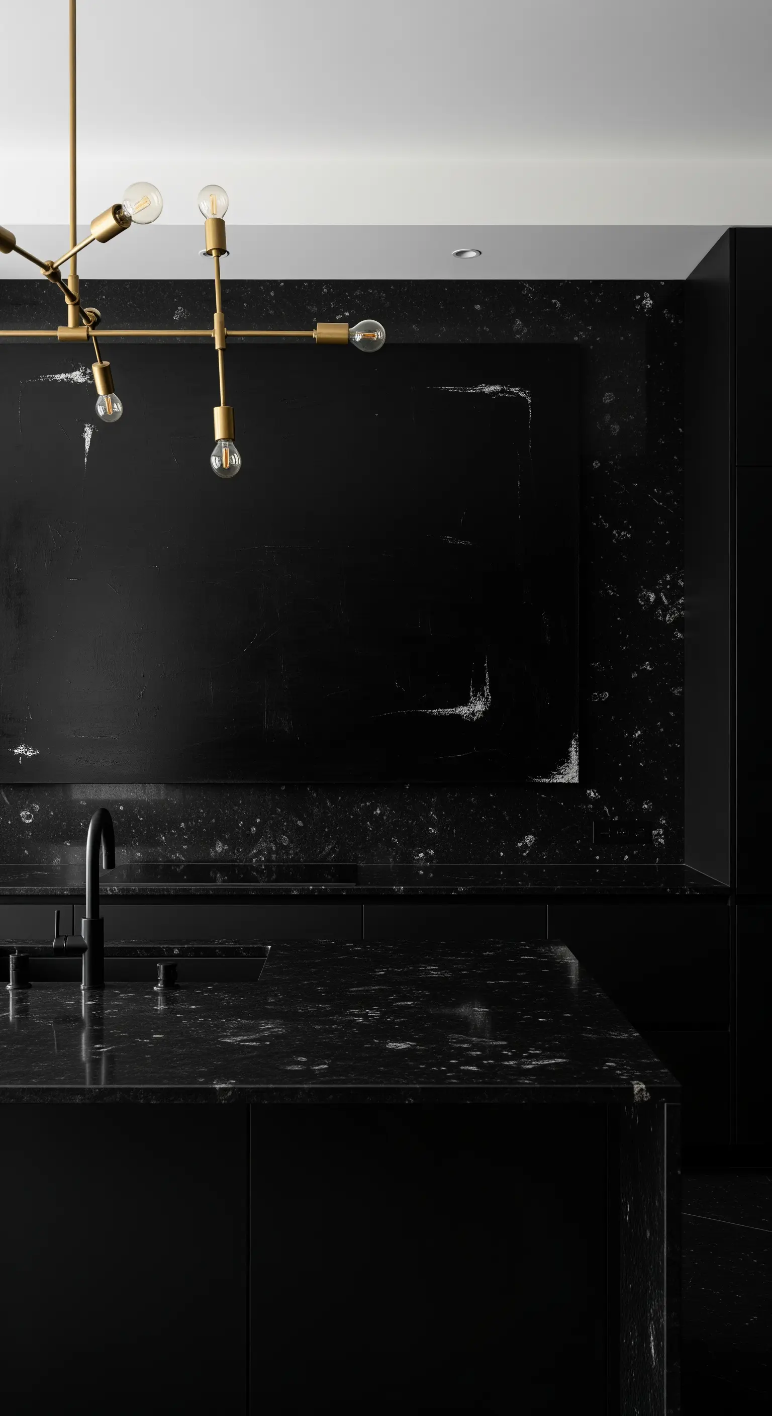 Cucina total black con top in marmo nero e un'opera d'arte materica nera.