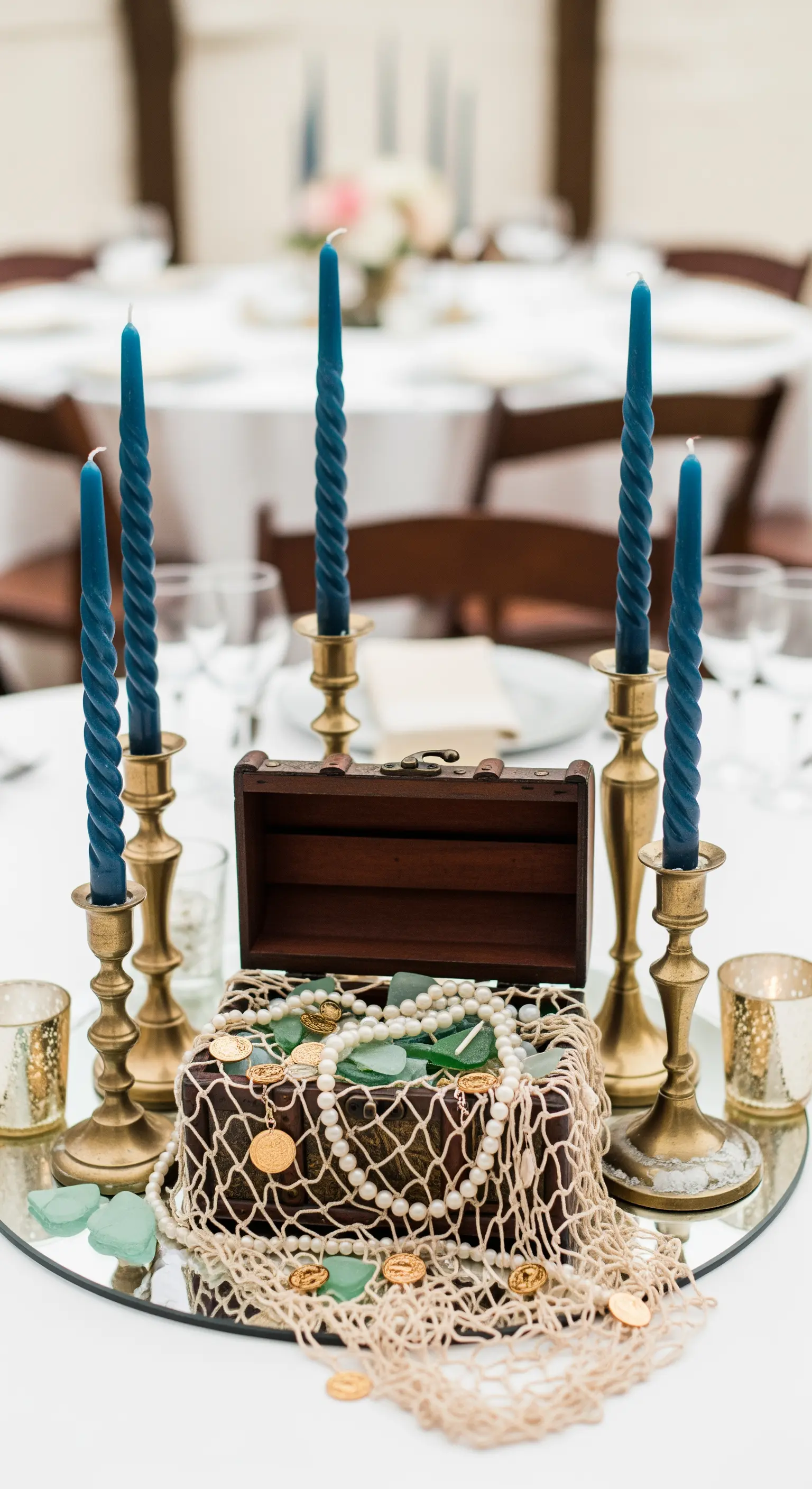 Centrotavola con forziere del tesoro, perle, monete e candele blu in portacandele d'ottone