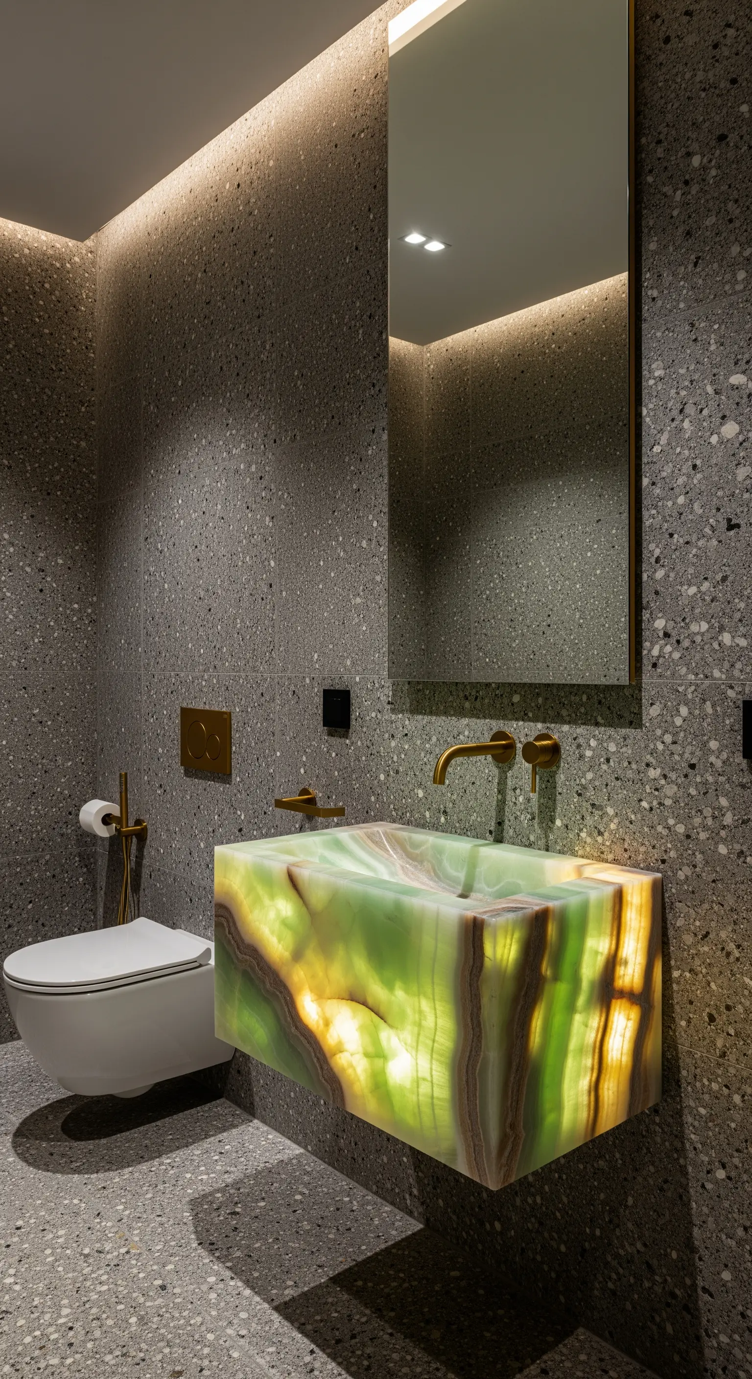 Lavabo sospeso in onice verde retroilluminato in un bagno con pareti effetto terrazzo.