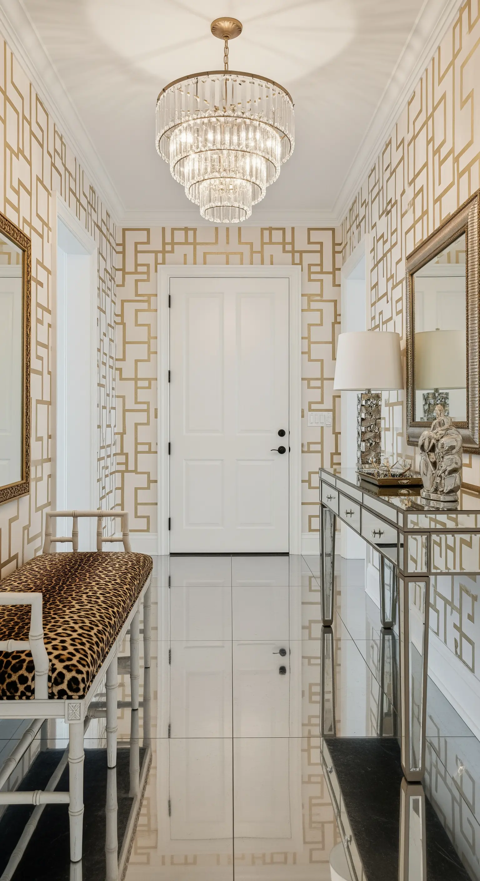 Ingresso glamour con carta da parati geometrica oro, panca leopardata e consolle a specchio.