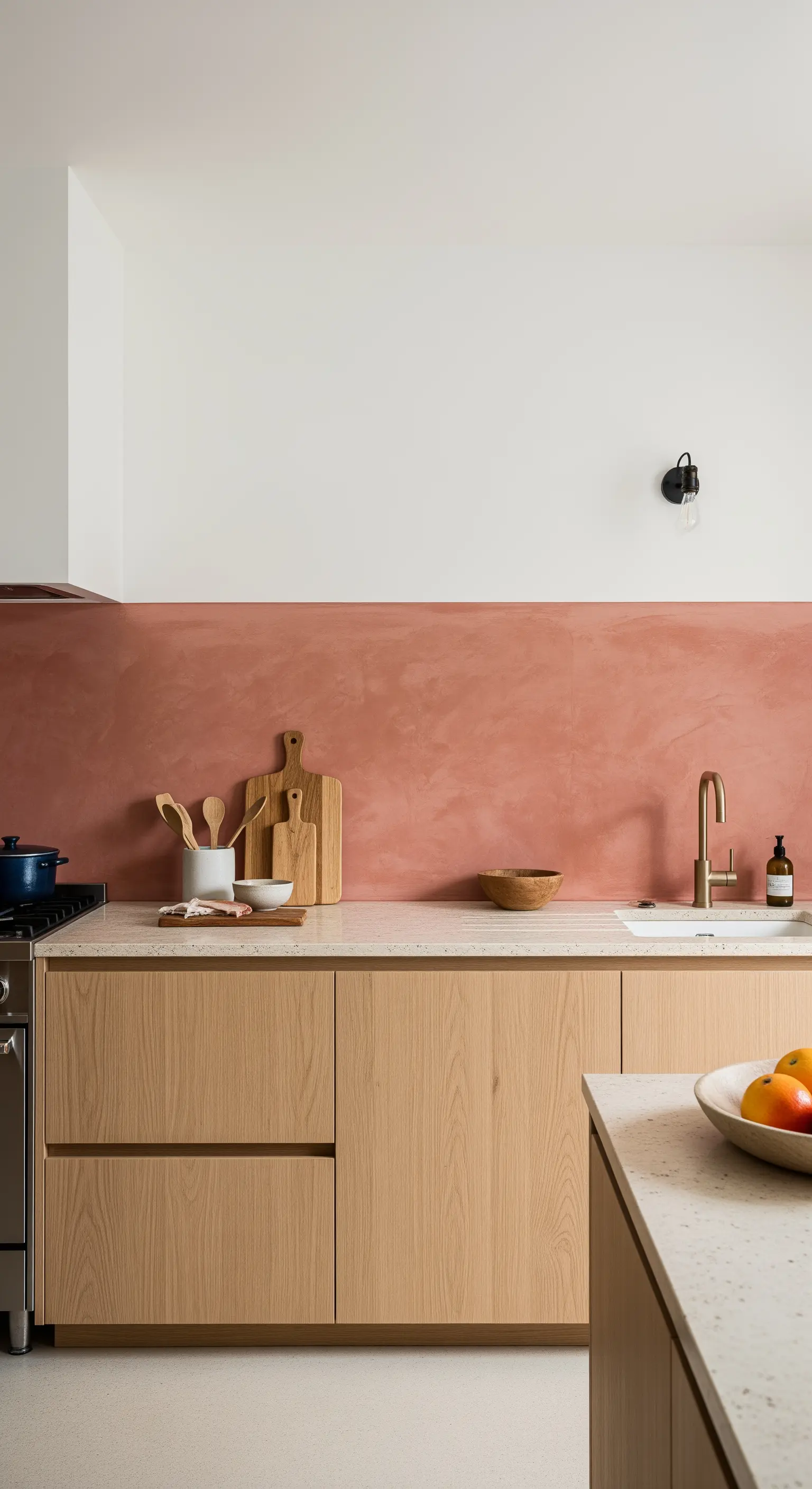 Cucina con mobili in rovere e un paraschizzi in resina color terracotta.