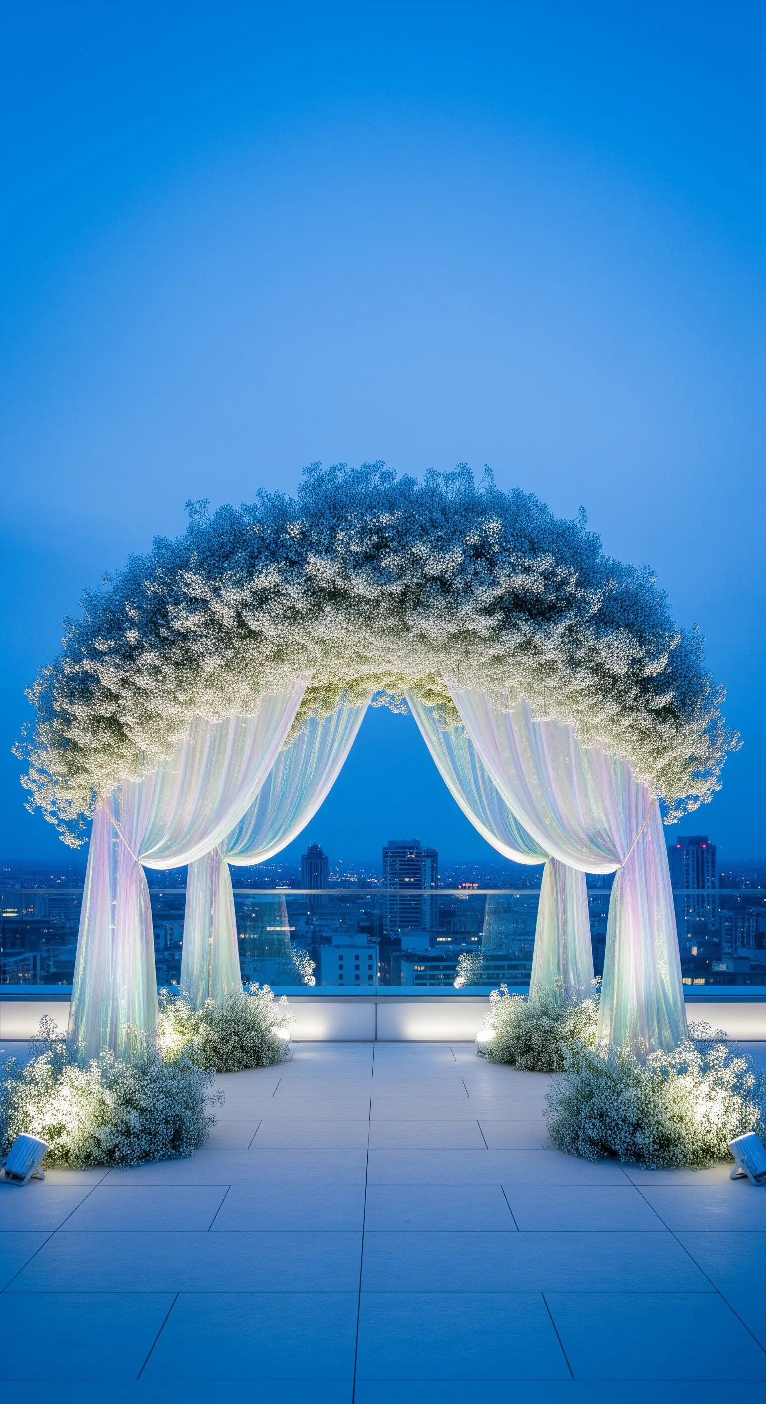 Arco di gypsophila e drappi iridescenti su una terrazza panoramica con vista sulla città.