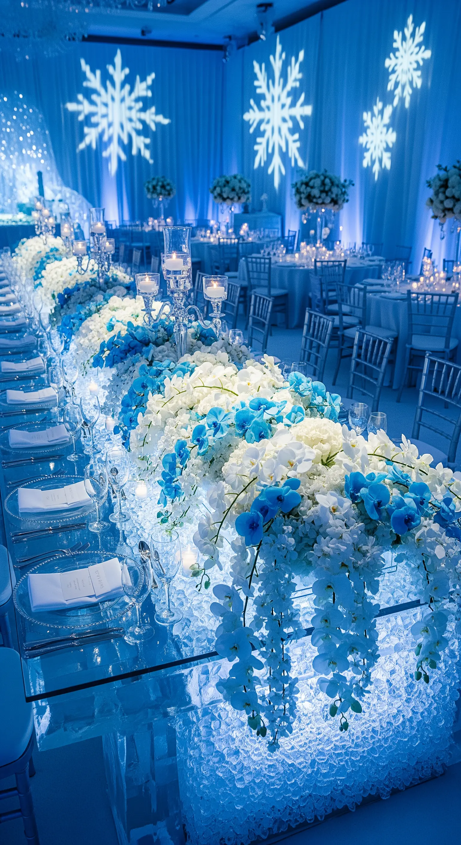 Tavolo imperiale con base illuminata effetto ghiaccio, decorato con orchidee bianche e blu.