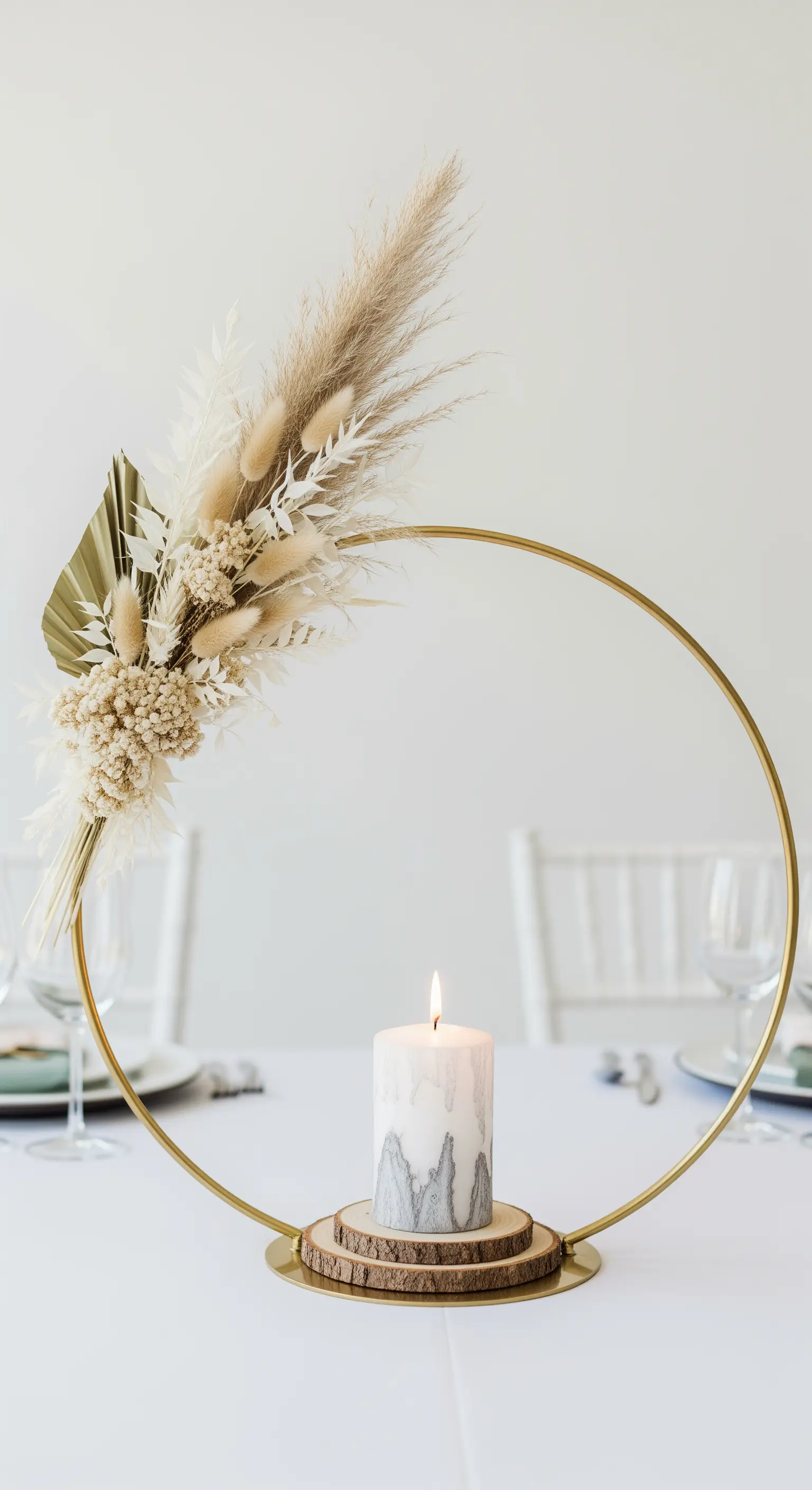 Cerchio dorato decorato con pampas grass e candela su base di legno.
