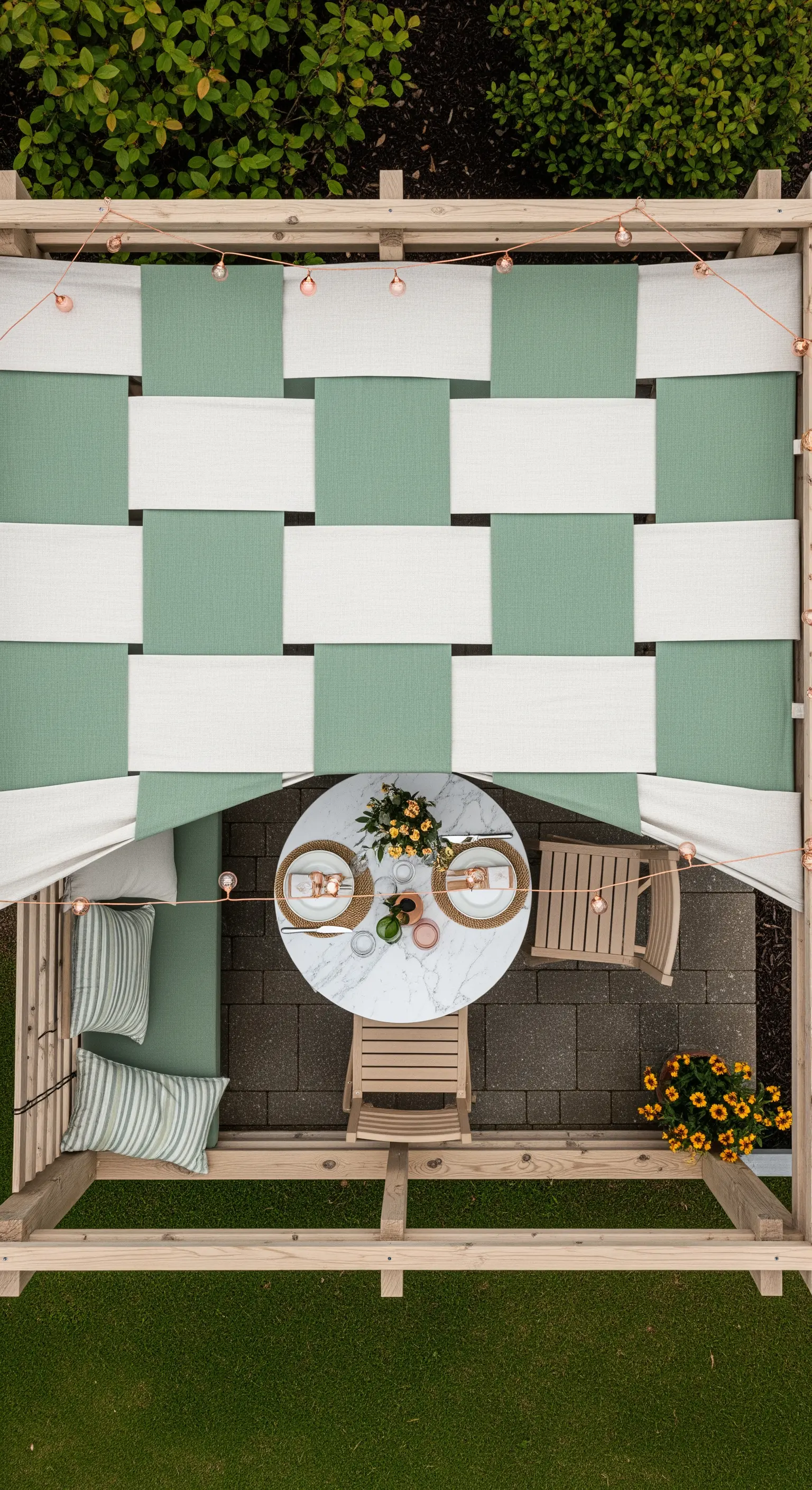 Vista dall'alto di un pergolato con copertura in tessuto intrecciato bianco e verde.