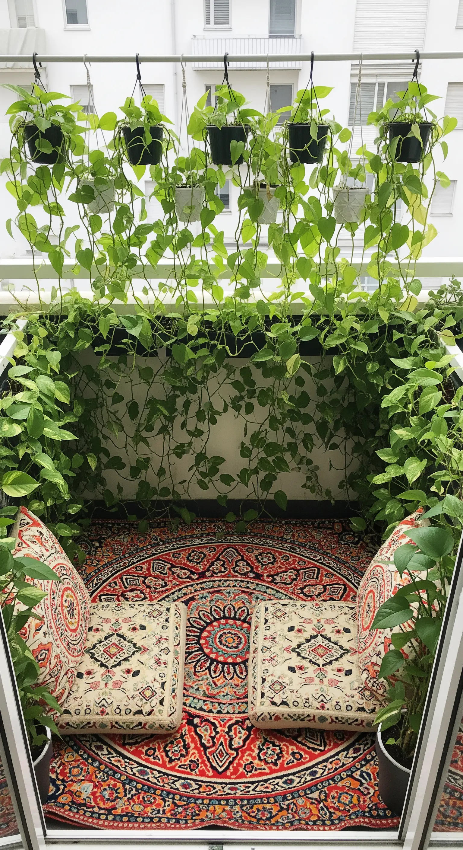 Piccolo balcone trasformato in un nido accogliente con tappeto rotondo e piante rampicanti.