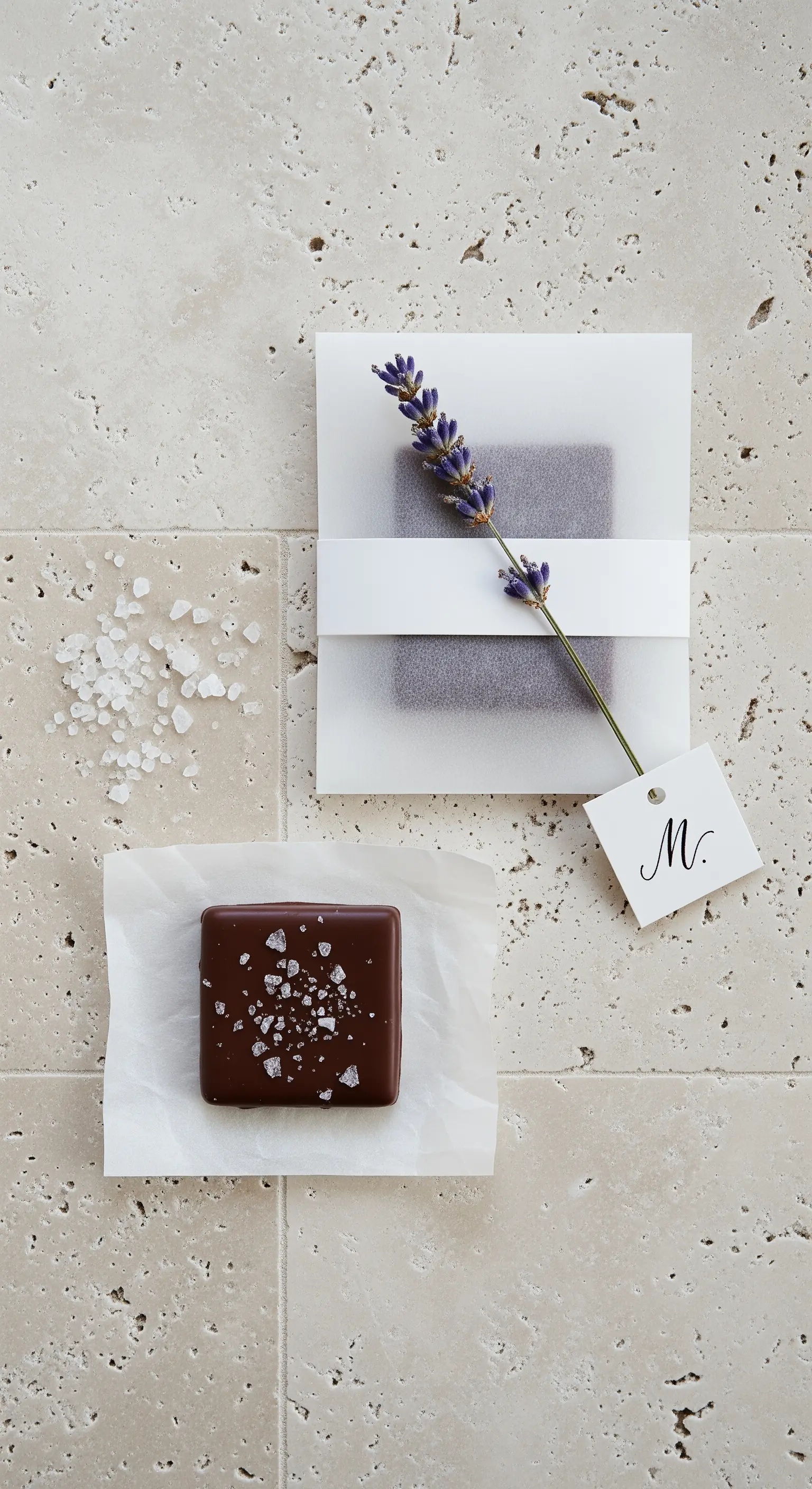 Tavoletta di cioccolato al sale avvolta in carta pergamena con un rametto di lavanda.